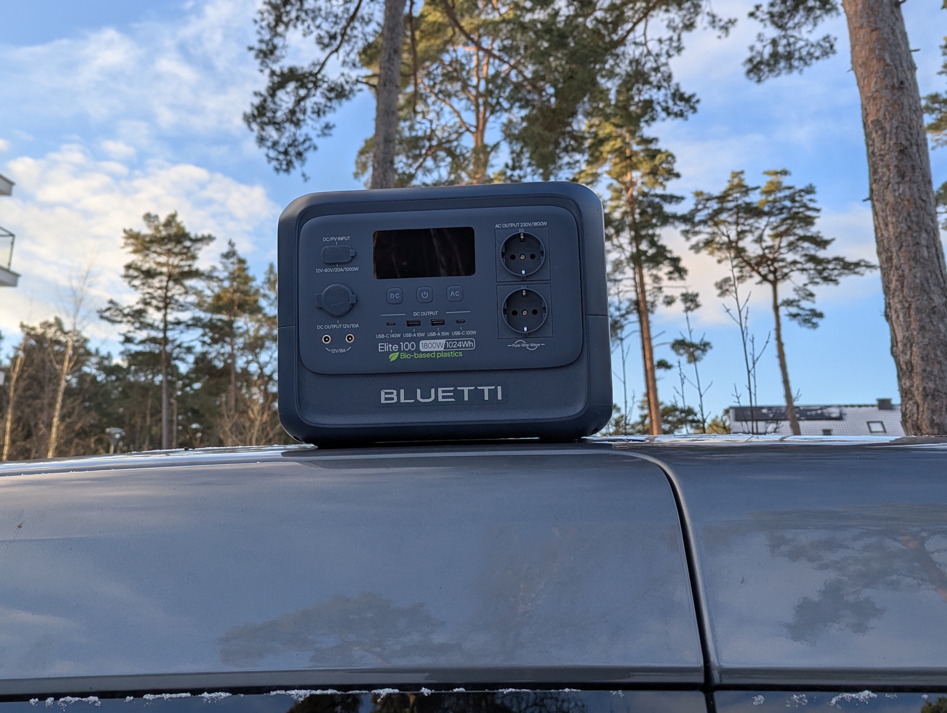 Bluetti Elite 100 V2 à base biologique sur le toit d'une voiture avec des pins en arrière-plan