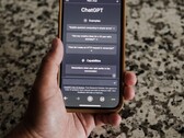 Une main tenant un smartphone sur lequel l'interface de ChatGPT est ouverte