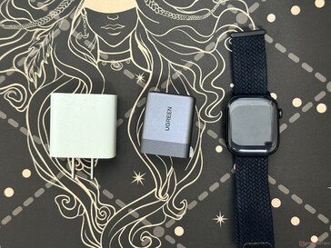 Comparaison de taille entre l'Ugreen Nexode Air 65 W, la montre Apple et un chargeur 18 W