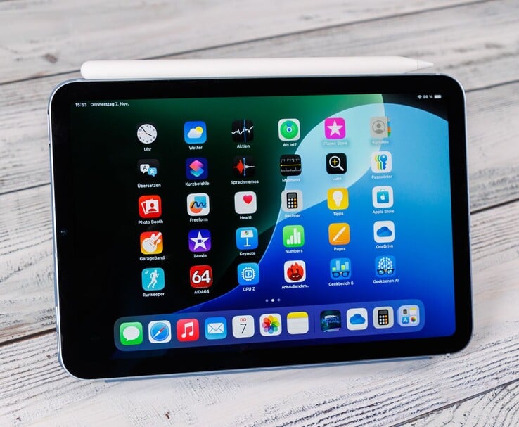 Vue de face d'un iPad mini avec le Pencil Apple posé sur le dessus, montrant l'écran d'accueil lorsqu'il est placé sur une surface en bois. (Source de l'image : Notebookcheck)
