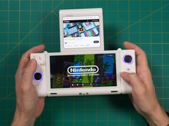 Russ de Retro Game Corps tenant la console de jeu portable à double écran OneXSugar Sugar 1, avec un jeu Nintendo sur l'écran principal et une vidéo YouTube sur l'écran secondaire. (Source de l'image : Retro Game Corps sur YouTube)