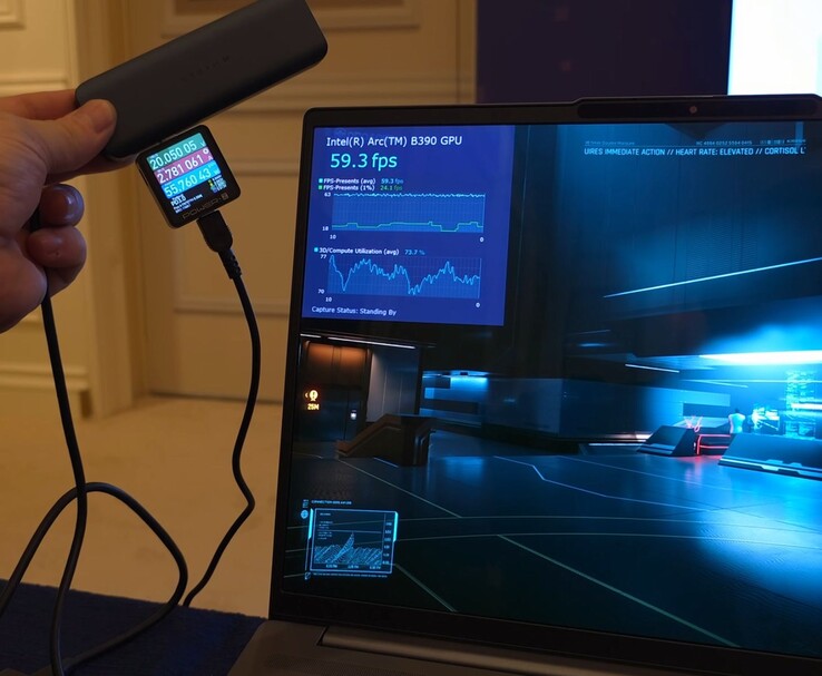 Ordinateur portable de référence Intel Panther Lake exécutant un jeu avec Intel Arc B390 iGPU performance overlay visible, tandis qu'un wattmètre externe mesure la consommation d'énergie pendant le jeu (Image source : ETA Prime via YouTube)