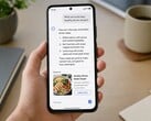 Une main tenant un smartphone affichant une réponse générée par l'IA, avec une publicité sponsorisée en dessous