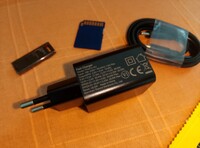 Le chargeur et le câble, une carte SD et une clé USB pour l'échelle (Image source : Sergey Tarasov - Notebookcheck)