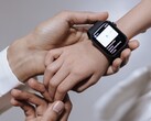 Une main d'adulte en train de régler une montre connectée au poignet d'un enfant