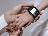 Une main d'adulte en train de régler une montre connectée au poignet d'un enfant