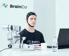 Un utilisateur de la technologie de contrôle mental de BrainCo saisissant mécaniquement une pomme par la seule force de la pensée.