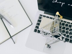 Mini-panier d'achat sur le clavier d'un ordinateur portable, avec la mention « Acheter maintenant » à l'écran