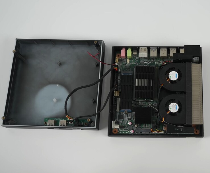 Ouverture du mini PC de jeu Yohris, montrant le système de refroidissement à double ventilateur, la carte mère et les emplacements évolutifs (Source d'image : ETA PRIME/YouTube)