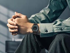 Une Citizen Eco-Drive One AR5065-54W au poignet, dotée d'un cadran vert forêt et noir, de détails en or rose et d'un bracelet ultra-fin recouvert d'un revêtement noir.