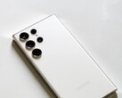 Smartphone Samsung Galaxy blanc doté de quatre caméras arrière, posé sur une surface claire.
