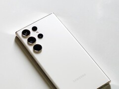 Smartphone Samsung Galaxy blanc doté de quatre caméras arrière, posé sur une surface claire.