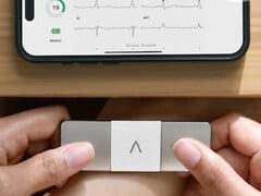 Un AliveCor KardiaMobile 6L Max tenu à deux mains pour mesurer l&#039;ECG d&#039;une personne. (Source de l&#039;image : AliveCor)