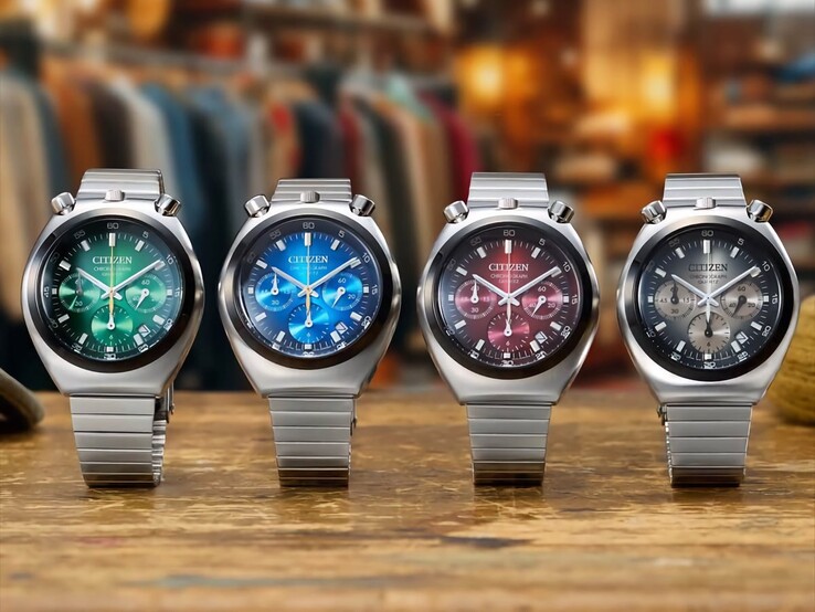 Quatre montres chronographes Citizen Tsuno présentées côte à côte sur une surface en bois, avec des cadrans dégradés verts, bleus, rouges et gris, en acier inoxydable