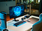 Une installation de jeu épurée en studio, comprenant le moniteur Sony Inzone M10S II posé sur un bureau blanc, à côté d’une console PlayStation 5 Pro placée à la verticale, d’un clavier mécanique, d’une souris sans fil et d’un casque doté d’un éclairage bleu discret.
