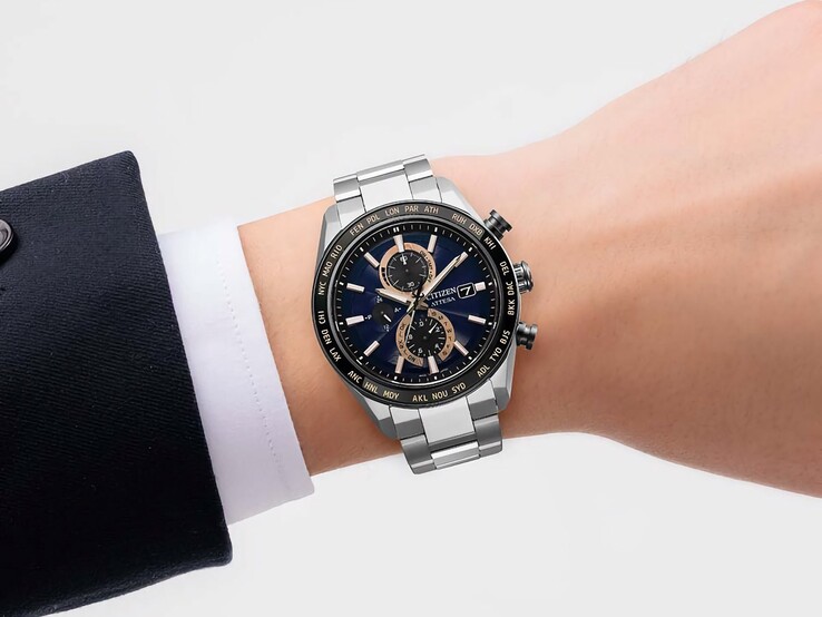 Chronographe Citizen Attesa AT8297-51L porté au poignet, avec son cadran bleu marine, ses accents or rose et sa lunette noire à heure universelle.