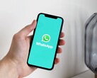 Main tenant un smartphone avec l’application WhatsApp ouverte