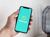 Main tenant un smartphone avec l’application WhatsApp ouverte