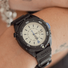 La Timex Intrepid x Dimepiece Blackout Edition présente un boîtier en acier inoxydable noir, un cadran crème et des touches de violet