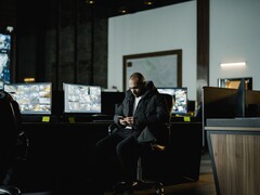 Un analyste en sécurité dans une salle de contrôle, devant plusieurs écrans