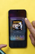 Un smartphone OnePlus affichant le widget du lecteur multimédia, sur lequel un utilisateur appuie sur l'icône de sortie audio pour accéder aux commandes de partage audio via Bluetooth.