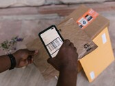 Une main tient un smartphone au-dessus d’un colis et scanne son code-barres.