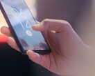 Une main tient un smartphone et le déverrouille à l'aide du capteur d'empreintes digitales situé sur l'écran de verrouillage.
