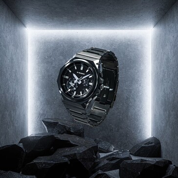 G-Shock GST-B1000BD-1A suspendue au-dessus de roches sombres dans un espace d'exposition en béton, mettant en valeur sa construction en acier inoxydable noir.
