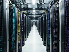 Rangées de baies de serveurs du centre de données Meta avec câblage à code couleur et systèmes d'alimentation électrique aériens à l'intérieur d'une salle de calcul à haute densité. (Source de l'image : Meta)