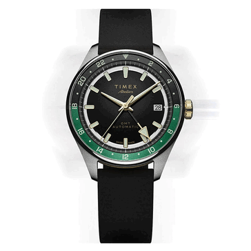Timex Atelier GMT Première M1a avec un cadran noir, un anneau GMT vert de 24 heures et un bracelet en caoutchouc NBR noir.