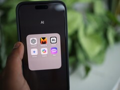 Main tenant un smartphone avec un dossier rempli d’applications d’IA à l’écran