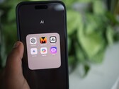 Main tenant un smartphone avec un dossier rempli d’applications d’IA à l’écran
