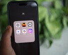 Main tenant un smartphone avec un dossier rempli d’applications d’IA à l’écran