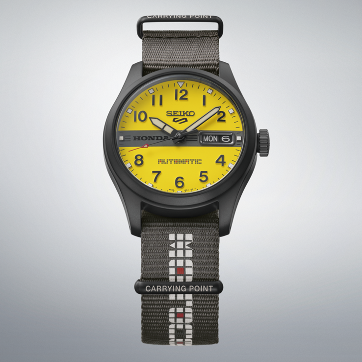 Vue de face de la Seiko 5 Sports Field x Honda Motocompo en édition limitée, dotée d’un cadran jaune, d’un logo Honda noir au centre et d’un bracelet en nylon gris.