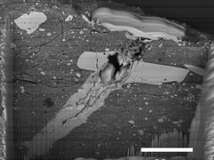 Image au microscope électronique à balayage d'un cratère d'impact de micrométéorite dans une particule de matériau de l'astéroïde Bennu (Source de l'image : NASA, et Zia Rahman)