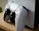 Une photo d’une manette DualSense PlayStation 5 appuyée contre une console PS5