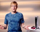  Mark Cerny lors d'un événement PlayStation, assis à côté d'une console PS5 et de manettes DualSense. (Source de l'image : Sony Interactive Entertainment)