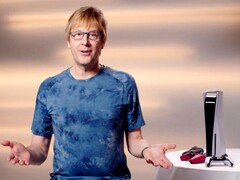  Mark Cerny lors d'un événement PlayStation, assis à côté d'une console PS5 et de manettes DualSense. (Source de l'image : Sony Interactive Entertainment)