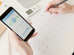 Une main tenant un smartphone sur lequel est ouverte une application de santé
