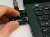 Une personne insère une clé USB de sécurité dans un ordinateur portable