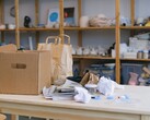 Boîte en carton et sacs en papier sur une table en bois dans un bureau avec des étagères
