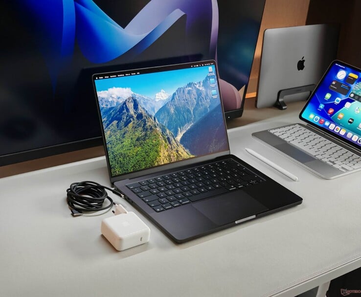 Apple MacBook Pro sur un bureau avec chargeur et écrans externes (Image source : Notebookcheck)