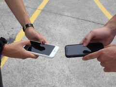 Deux personnes tenant deux smartphones côte à côte lors d’une remise