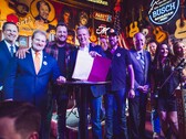Le gouverneur du Tennessee, M. Lee, brandit la loi ELVIS après l'avoir signée aux côtés de législateurs et de musiciens. (Source : Brandon Hull pour le bureau du gouverneur de l'État du Tennessee)