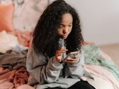Adolescent utilisant un smartphone sur un lit, image symbolique de ChatGPT for Teens et du contrôle parental