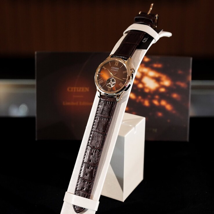 La montre Citizen posée sur un présentoir blanc incurvé. L’image met en valeur toute la longueur du bracelet en cuir marron foncé à motif croco ainsi que le cadran marron réfléchissant,
