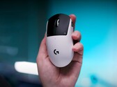 Souris de jeu Logitech G Pro X2 Superstrike dans une main sur fond bleu