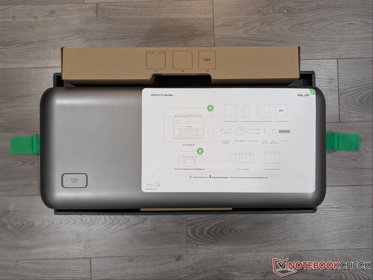 Imprimante UV E1 dans sa boîte avec les instructions d'installation.