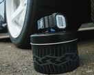 Montre Casio G-Shock DW5600TT25-1 x Toyo Tires présentée sur une boîte métallique sur le thème des pneus, à côté d'une roue de voiture.
