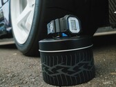 Montre Casio G-Shock DW5600TT25-1 x Toyo Tires présentée sur une boîte métallique sur le thème des pneus, à côté d'une roue de voiture.